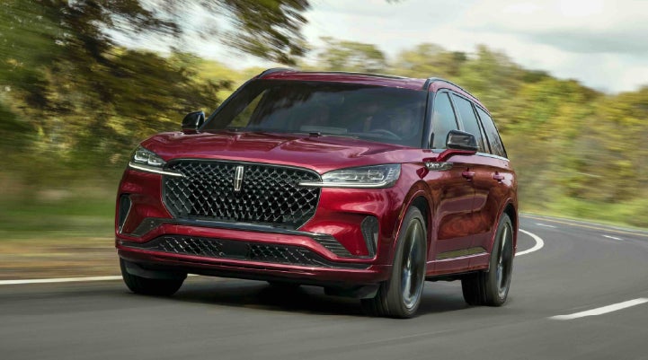 A 2027 Lincoln Aviator® SUV is being driven on a country road | Dave Sinclair Lincoln in Ballwin MO