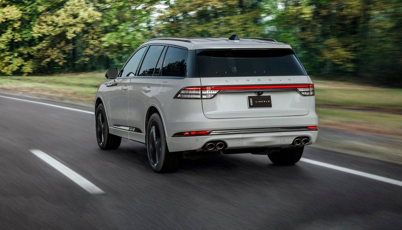 White Lincoln Aviator seen from behind driving on a country road